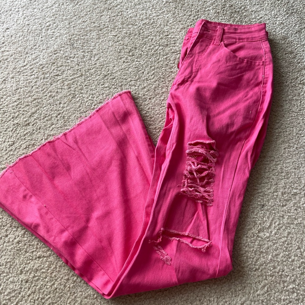Bright pink distressed bootcut jeans
